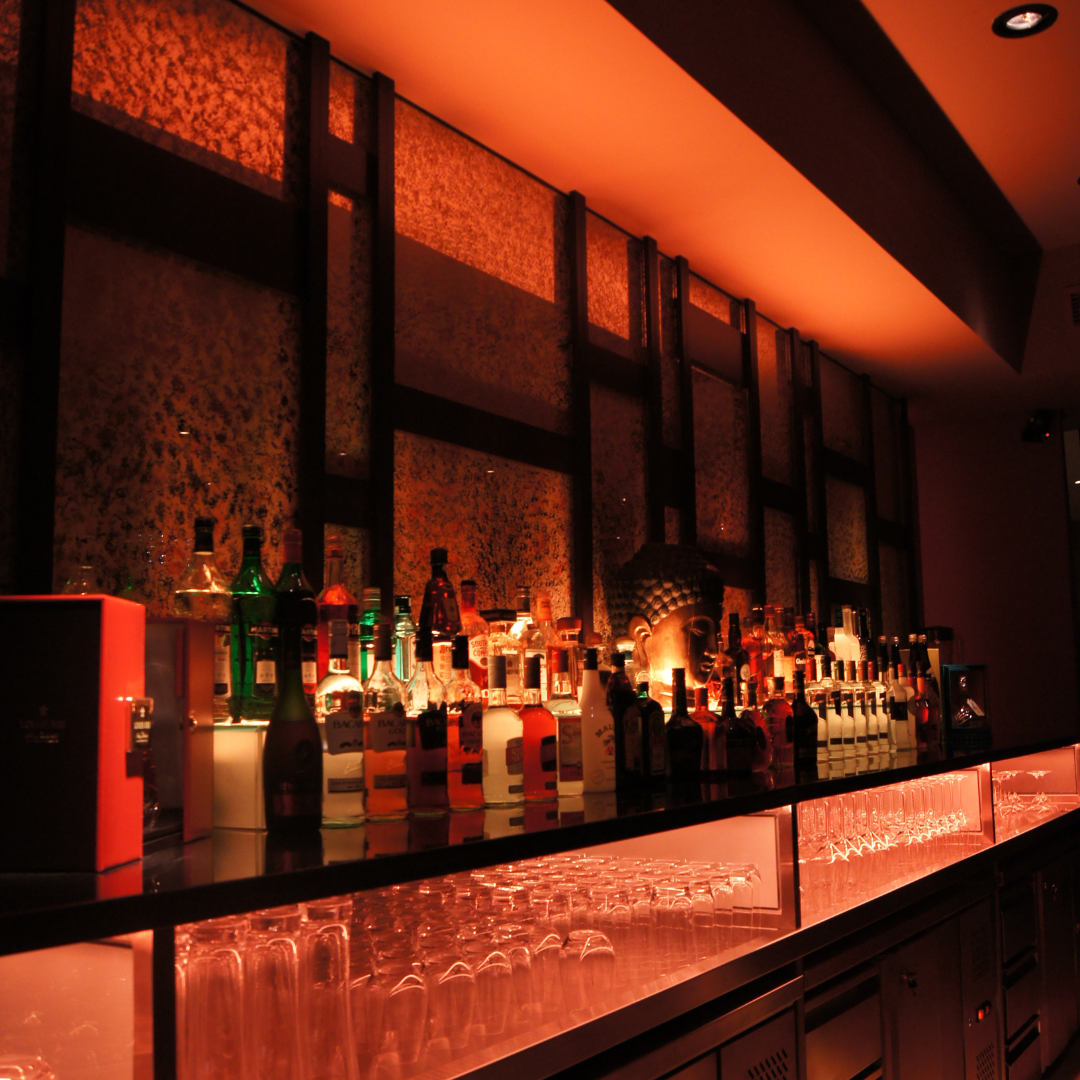 Moody Boar Cross'n back bar with bottles and warm amber light
